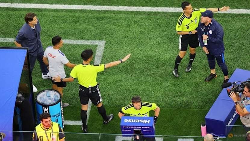 Wasit dan staf tim berdiskusi di tepi lapangan saat laga USA vs Paraguay